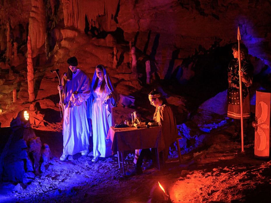Amateur actors in stage costumes perform during a live Nativity scene at an underground cave in Post